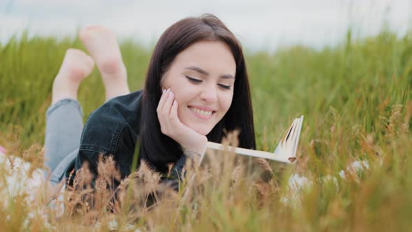 Young Serene Caucasian Brunet Woman Girl Lying on Grass Outdoors Attractive Smiling Teenage Student