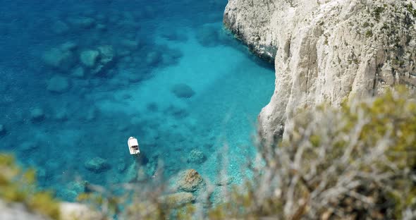 Lonely Pleasure Boat in Blue Bay with Secluded Beach