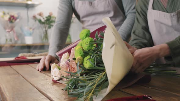 Florists Decorating Bouquet Of Flowers