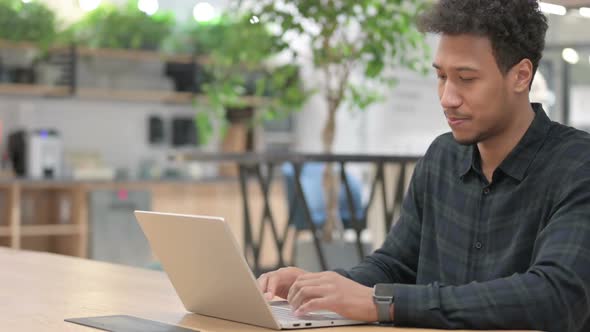 African American Man Working on Laptop in Office