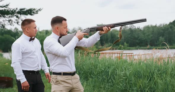 Two Men Friends Shooting the Gun a Strong Shot with Recoil