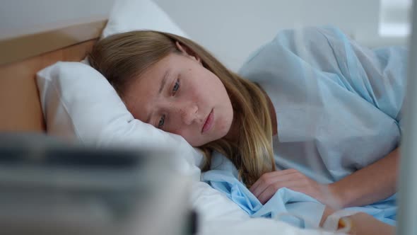 Frustrated Devastated Caucasian Teenage Girl Lying in Bed in Medical Clinic Thinking