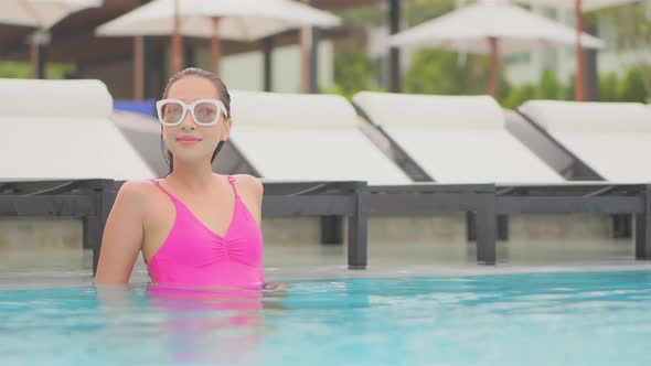 Young asian woman enjoy around outdoor swimming pool for leisure