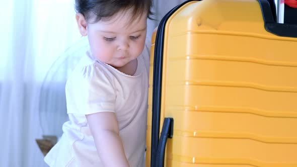 Baby Girl with Yellow Suitcase Baggage and Clothes Ready for Traveling on Vacation Child Playing