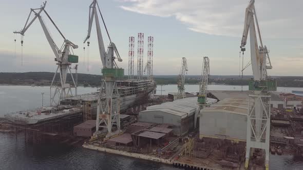 Construction Cranes At The Shipyard In Twiligh