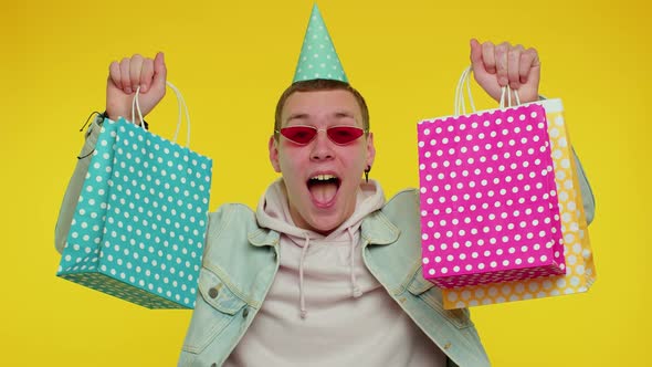 Teen Man Showing Shopping Bags Advertising Discounts Low Prices Shopping on Black Friday Holiday