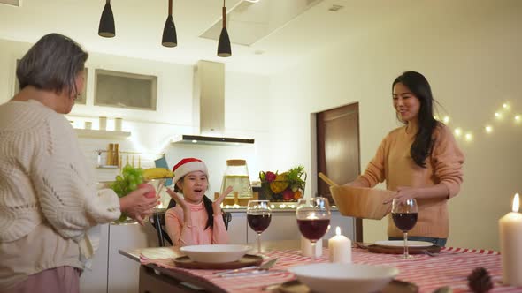 Asian happy family having Christmas holiday party and eat foods together on dinner table in house.