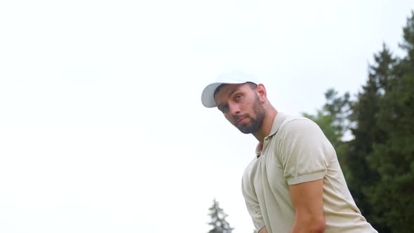 Young sportsman playing golf on the field