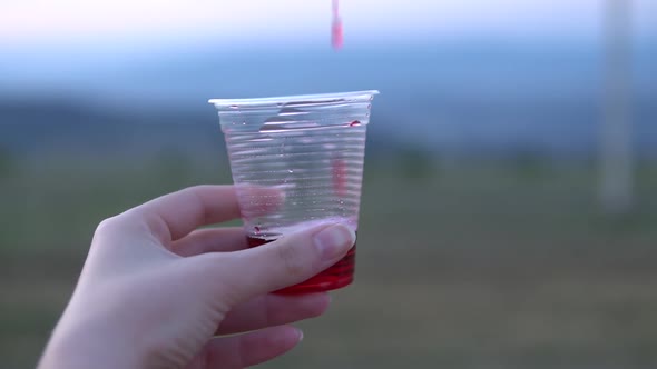 Juice slow motion Pouring in plastic cup