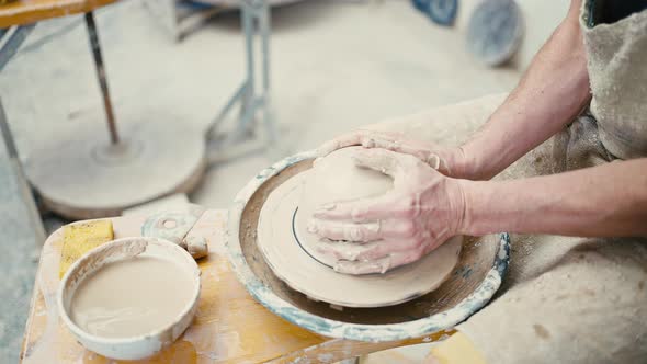 Close Up of Potter Sculpting Ceramic Crockery on Pottery Wheel Tracking Shot Slow Motion