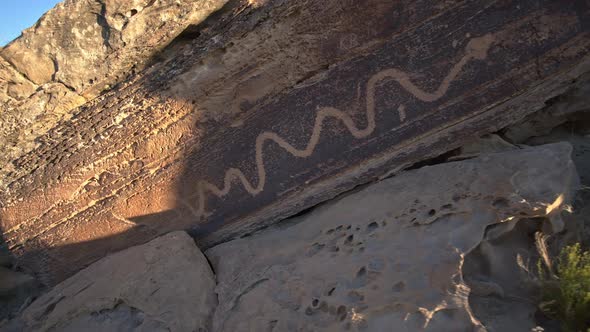 Walking up to boulder with snake petroglyph on it from native american