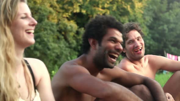 Four friends laughing while sitting in nature