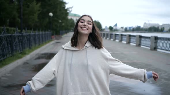 Brunette Is Taking a Walk Along the River Side