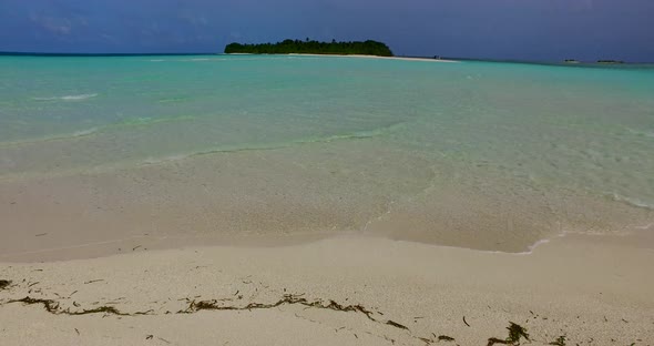 Wide angle fly over abstract shot of a white sandy paradise beach and blue ocean background in color