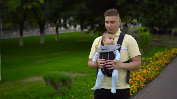 A Young Father Walks with a Child in the Park