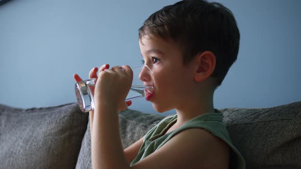 Cute Little Baby Boy Drinking a Glass of Water in Home