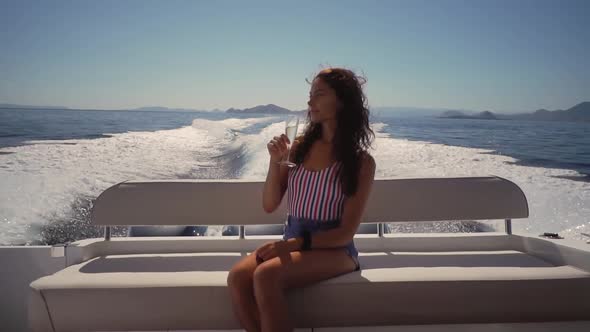 Young Pretty Brunette Relaxing on a Luxury Yacht Drinking Champagne Enjoying Splendid Sea Trip