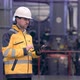 Engineer in Hard Hat is Moving Through a Heavy Industry Factory with a Tablet Computer - VideoHive Item for Sale