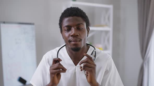 Portrait of Confident Male Doctor Hanging Stethoscope on Neck Smiling Looking at Camera