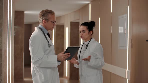 Two Therapists Discuss the Diagnosis of the Patient in the Corridor of the Hospital