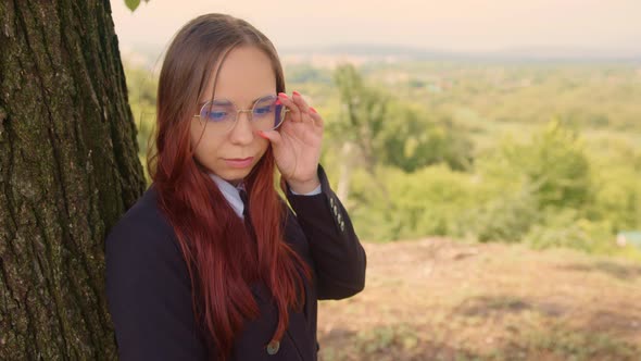 Young Woman in Glasses Business Suit Standing Near Tree in Nature