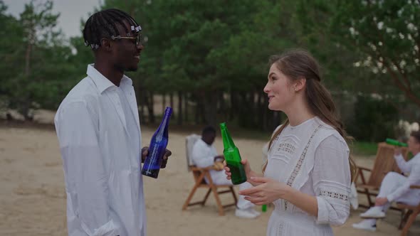 A Couple Talking and Drinking at the Campsite in Summer