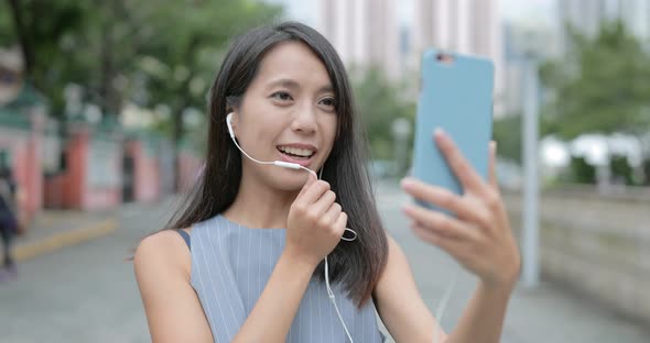 Woman making a video call with her cellphone in the city 