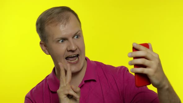 Portrait of Young Caucasian Man Posing in T-shirt. Handsome Guy Taking Selfies on the Smartphone