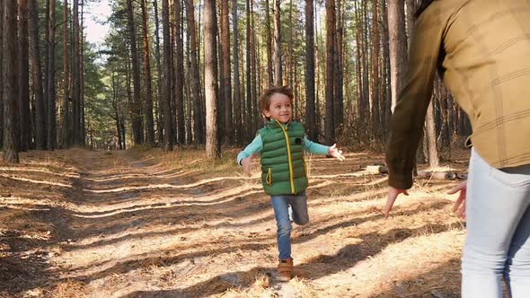 Happy Child Running on the Road in the Forest and Laughing. The Boy Runs Against the Background of