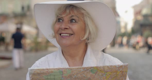 Senior Female Tourist Exploring Town with a Map in Hands, Looking for the Route