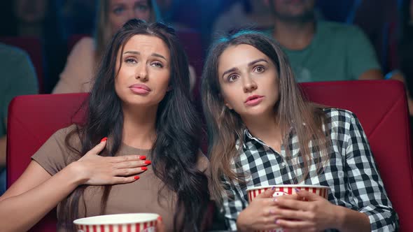 Closeup Two Female Friends Watching Film at Cinema Gossiping Discussing Actors Melodrama Scene