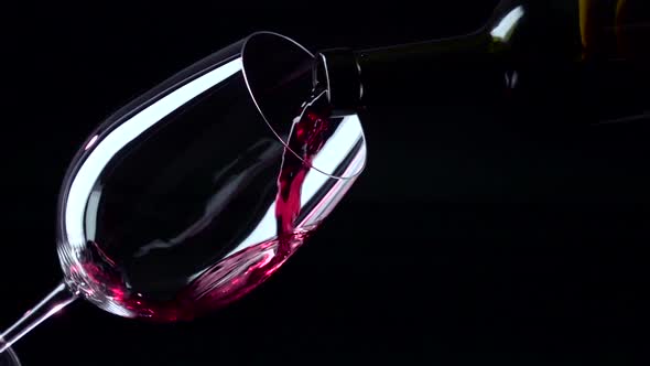 Bottle and Glass with Red Luxury Wine, Black, Closeup, Slowmotion