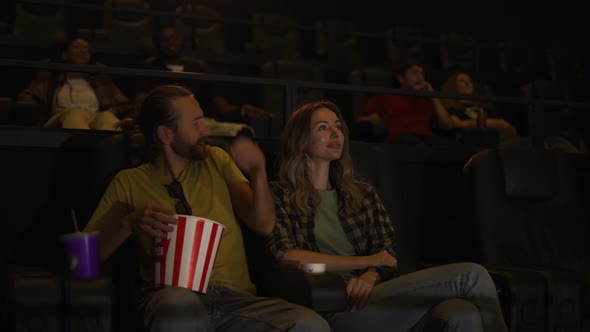 Couple Have a Date at the Cinema Sitting Embracing