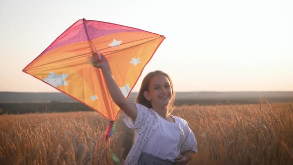Pretty Girl Playing with Kite in Wheat Field on Summer Day. Childhood, Lifestyle Concept.