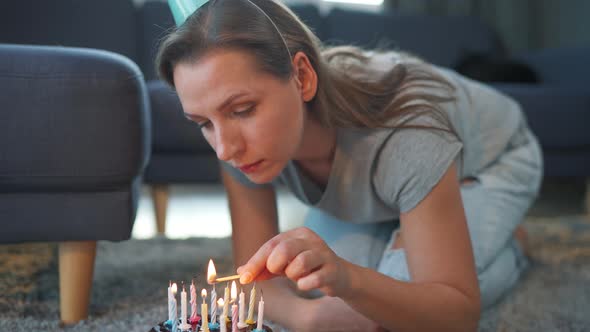 Woman Lighting Candles on Birthday Cake Celebrating Birthday at Home