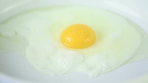 Time-lapse. Frying sunny-side-up fresh farm egg.