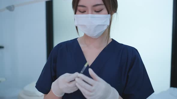 Beauty clinic nurse or staff prepare medicine or vaccine in syringe by holding and lift up