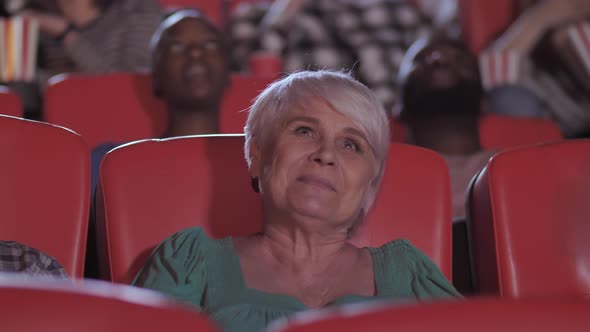 Elderly Woman Watching Melodrama in Movie Theater