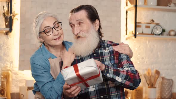 Elderly Loving Wife Greeting Husband with Gift Box