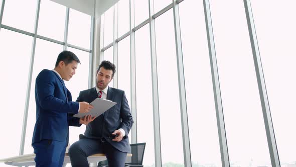 Two Business People Talk Project Strategy at Office