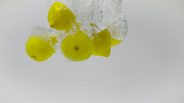 Sectioned lemons being dropped into water, Ultra Slow Motion alt