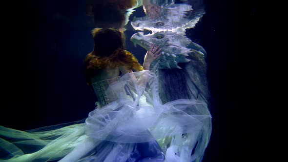 Fantasy Underwater Shot with Pretty Princess and Her Tamed Dragon Enchanted Prince