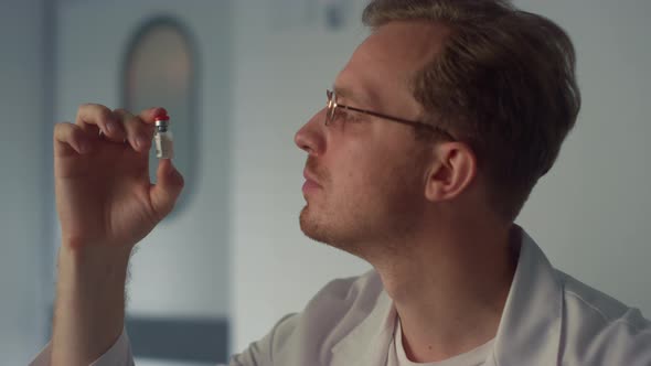 Doctor Examining Vaccine Vial Closeup