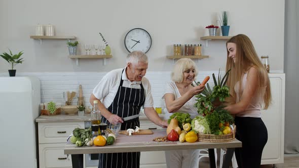 Elderly Couple in Kitchen Receiving Vegetables From Grandchild. Raw Food Healthy Eating Diet