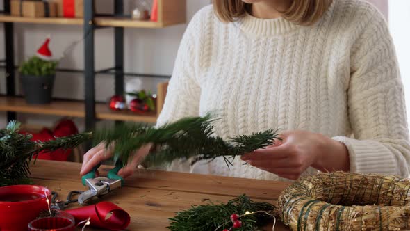 Happy Woman Making Fir Christmas Wreath at Home