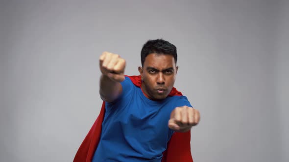 Indian Man in Superhero Cape Flying Over Grey