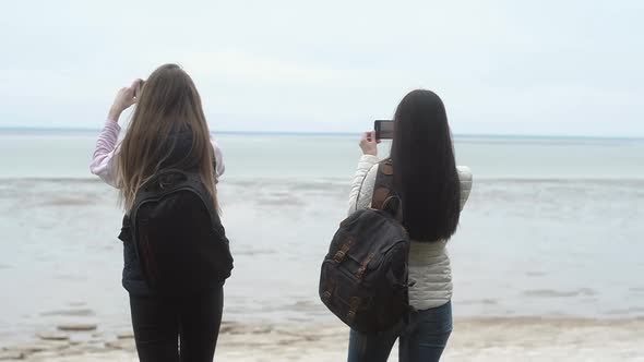 two girls edge cliff and shoot landscapes with phone camera create Fun selfies