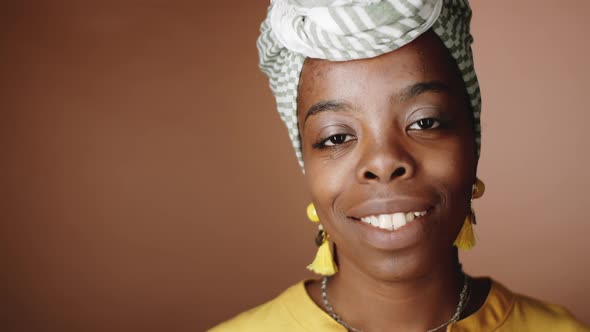 Portrait of Attractive Black Woman in Turban Smiling at Camera