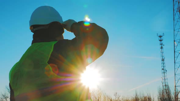 Silhouette Mature Engineer Working with Satellite Dish Telecom Network in Telecommunication Tower on