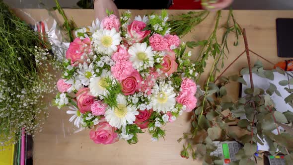 Top view of the hands of a young female florist creating a composition